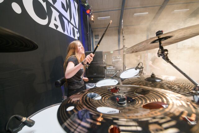 Eine junge Schlagzeugerin spielt beim Wacken Music Camp auf dem Drumset